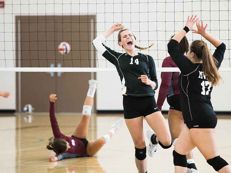 female students play volleyball